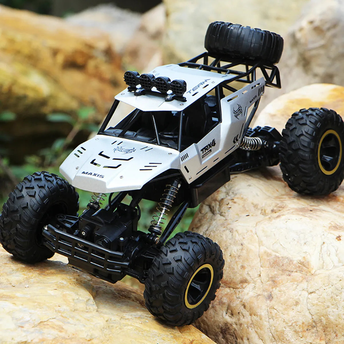 Black and silver remote control off-road car on rough terrain showing four-wheel drive and climbing capability.