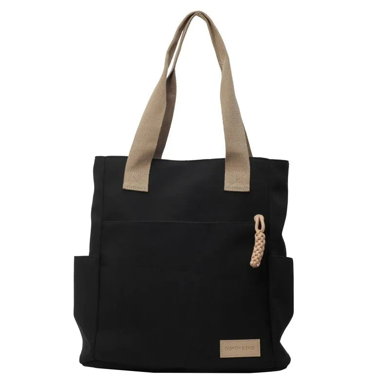 Women's large canvas satchel in beige with shoulder strap, horizontal square shape, and visible sewing thread details