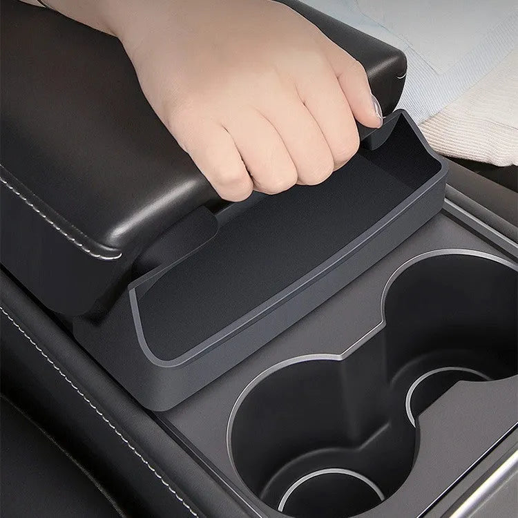 Black silicone sunglasses holder installed in Tesla centre console armrest compartment