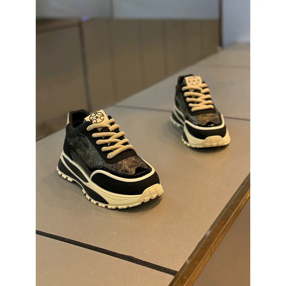 Pair of black retro lace-up daddy shoes with a thick rubber sole and rounded toe.