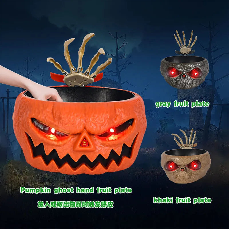 Plastic Halloween pumpkin candy bowl with motion activated skeleton hand, glowing red eyes, in Khaki colour, on a table with candy.