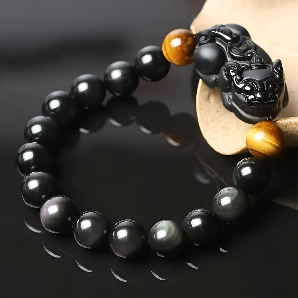 Mexico gold sheen obsidian Pi Xiu bracelet in unisex ethnic style on a wrist.