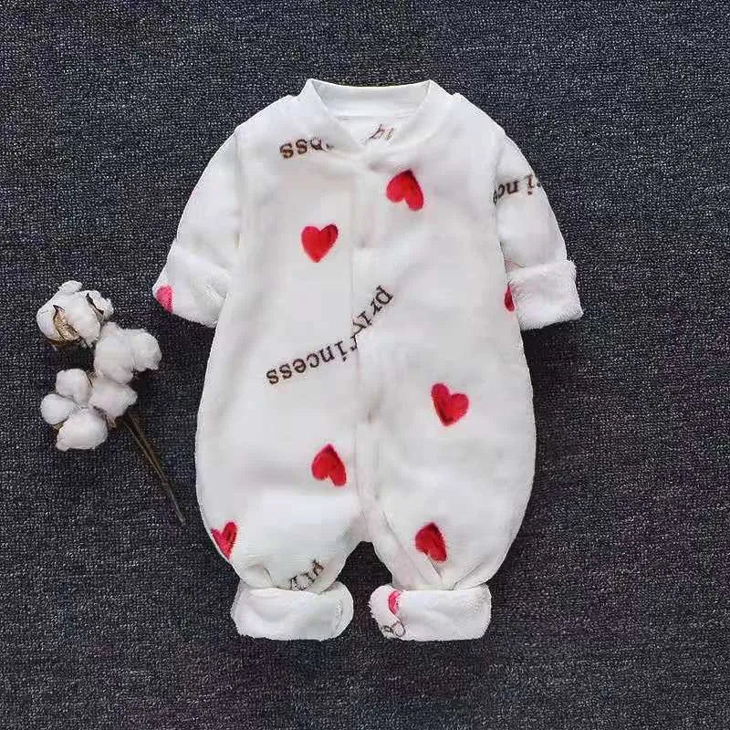Baby wearing a long-sleeved flannel romper in a pink bunny head print, showcasing the 100% cotton fabric.