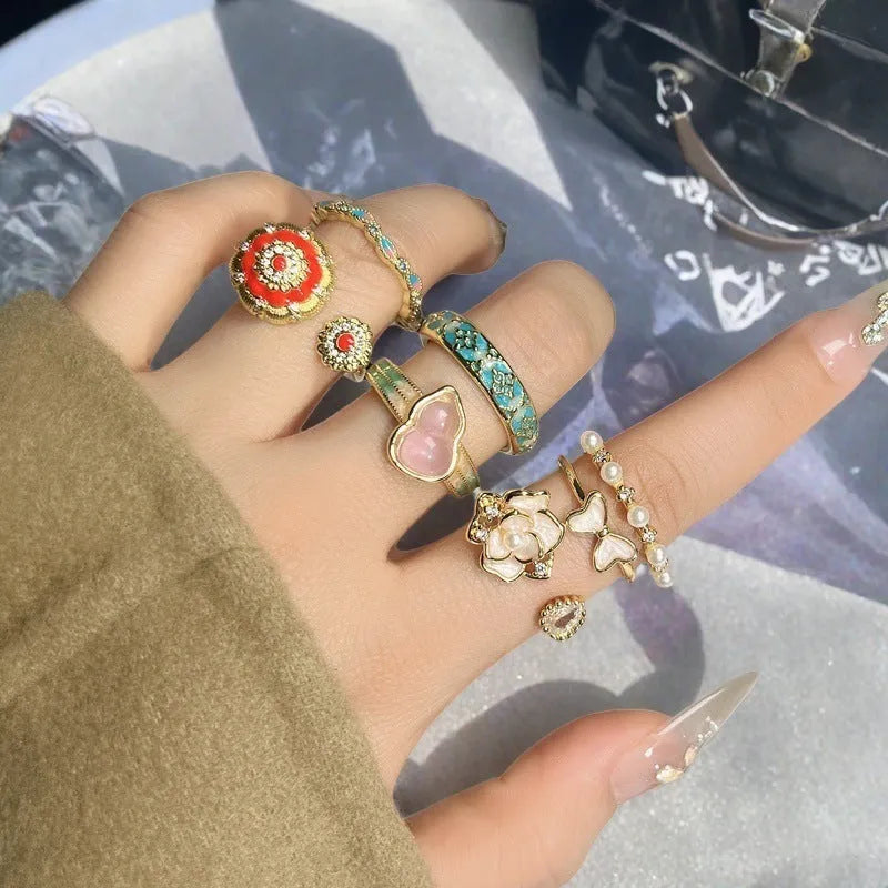 A copper vintage-style ring with a gourd motif, floral and bow designs, inlaid zircon stones, and an adjustable opening.