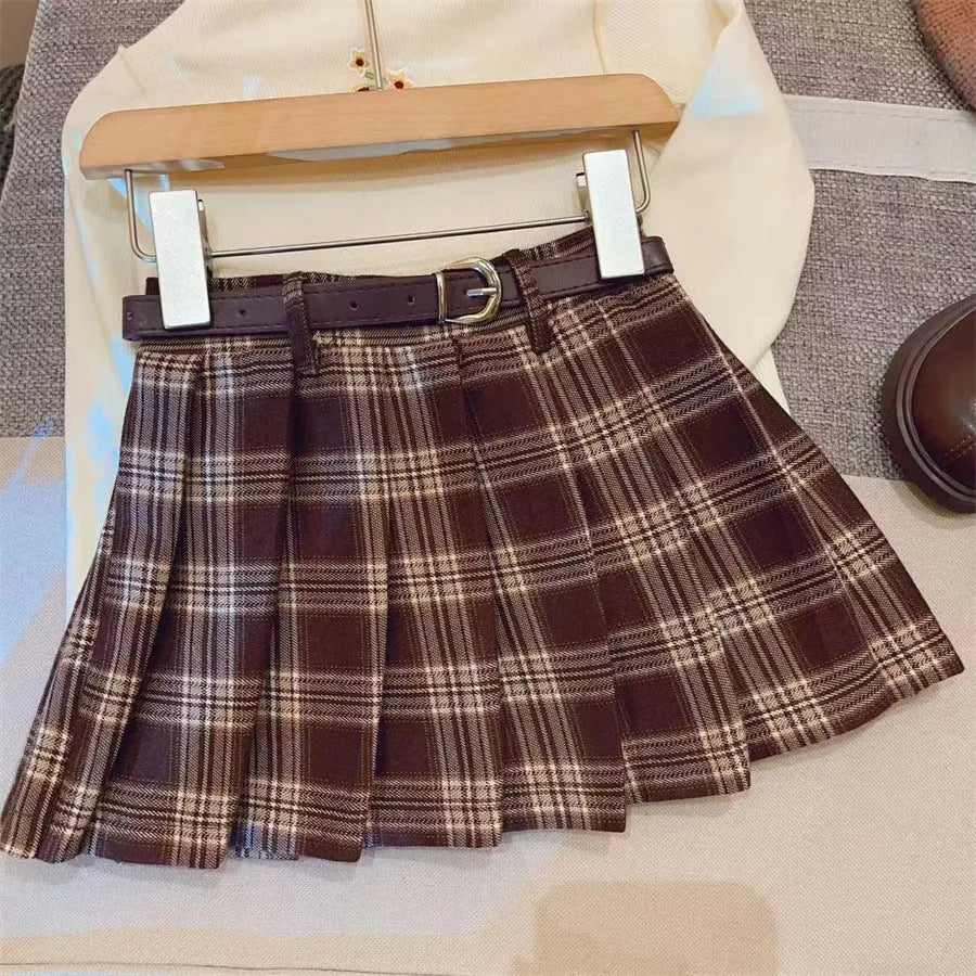 Girls cotton plaid pleated A-line skirt on a hanger, showing its length and pattern.