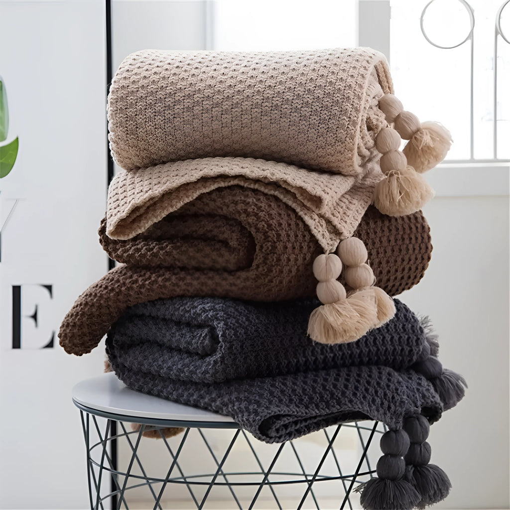 Nordic style fringed knit blanket in acrylic fabric, shown in beige colour, measuring 130 by 170 centimetres.