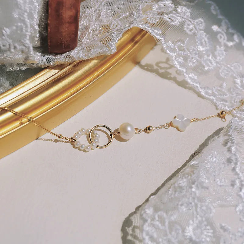 Close-up of a women's natural pearl bracelet with 14k gold-plated metal detailing.