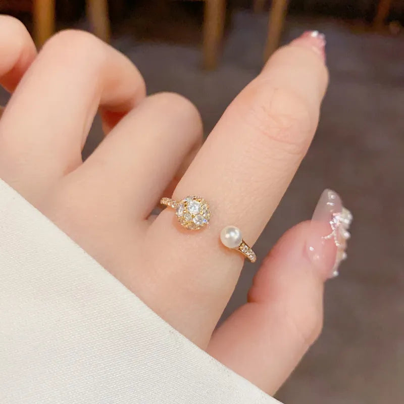 Gold and silver coloured open-end ring with round zircon on a geometric band.