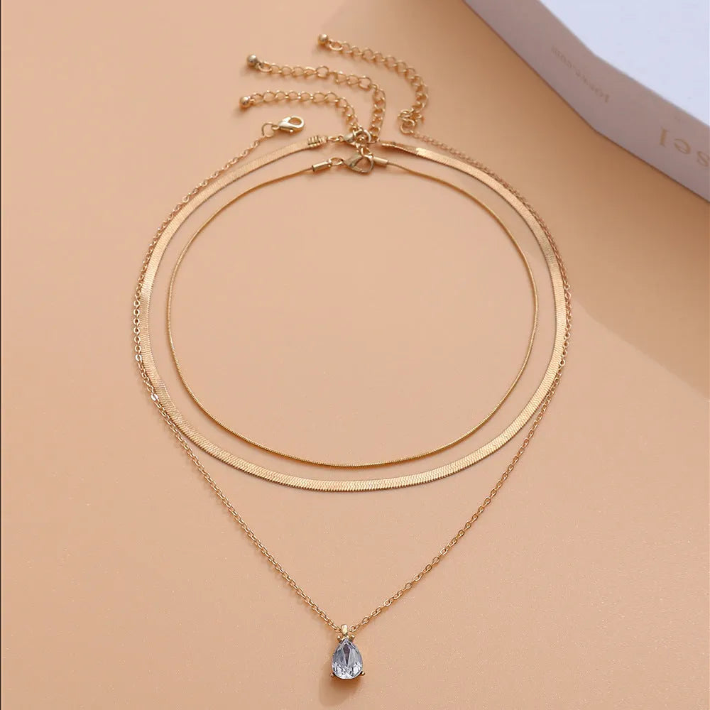 Gold and silver water drop shape alloy pendant necklace with electroplated finish on white background