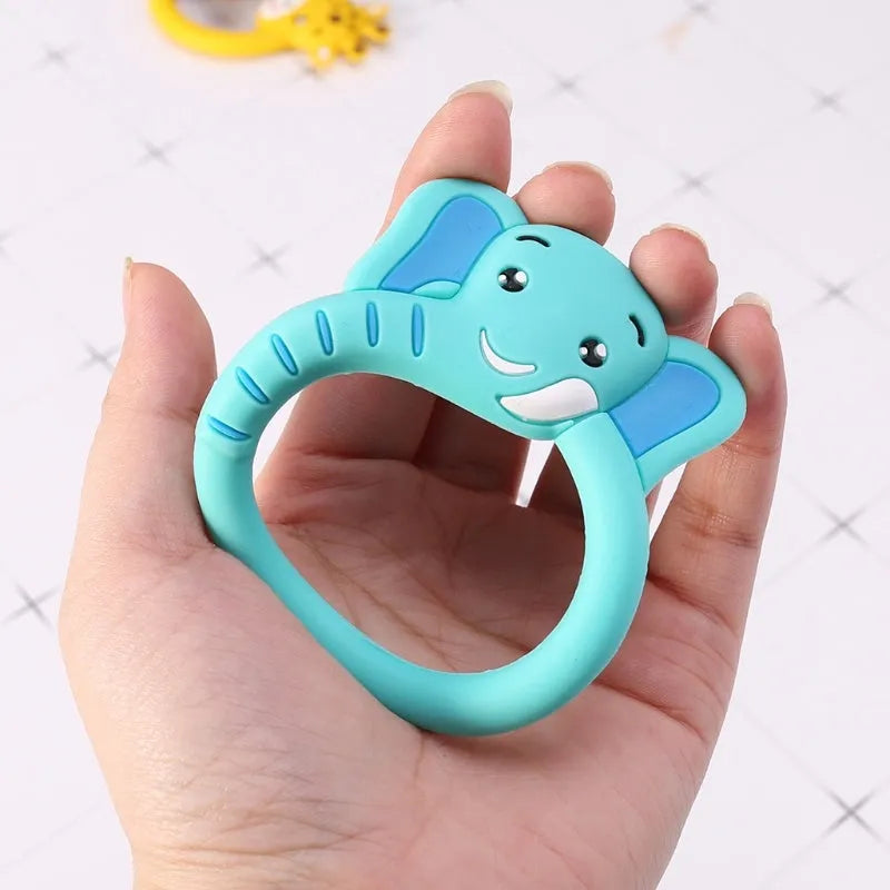 Three silicone baby molar teethers in brown, blue, and yellow on a light background