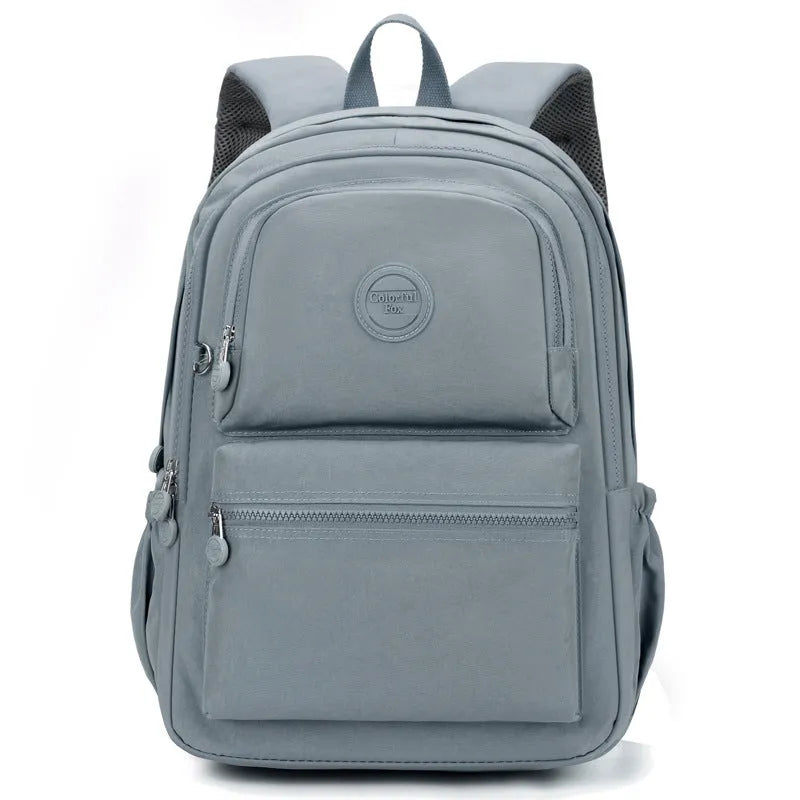 Women's nylon travel backpack in Azure Stone Green showing multiple compartments and organisational features