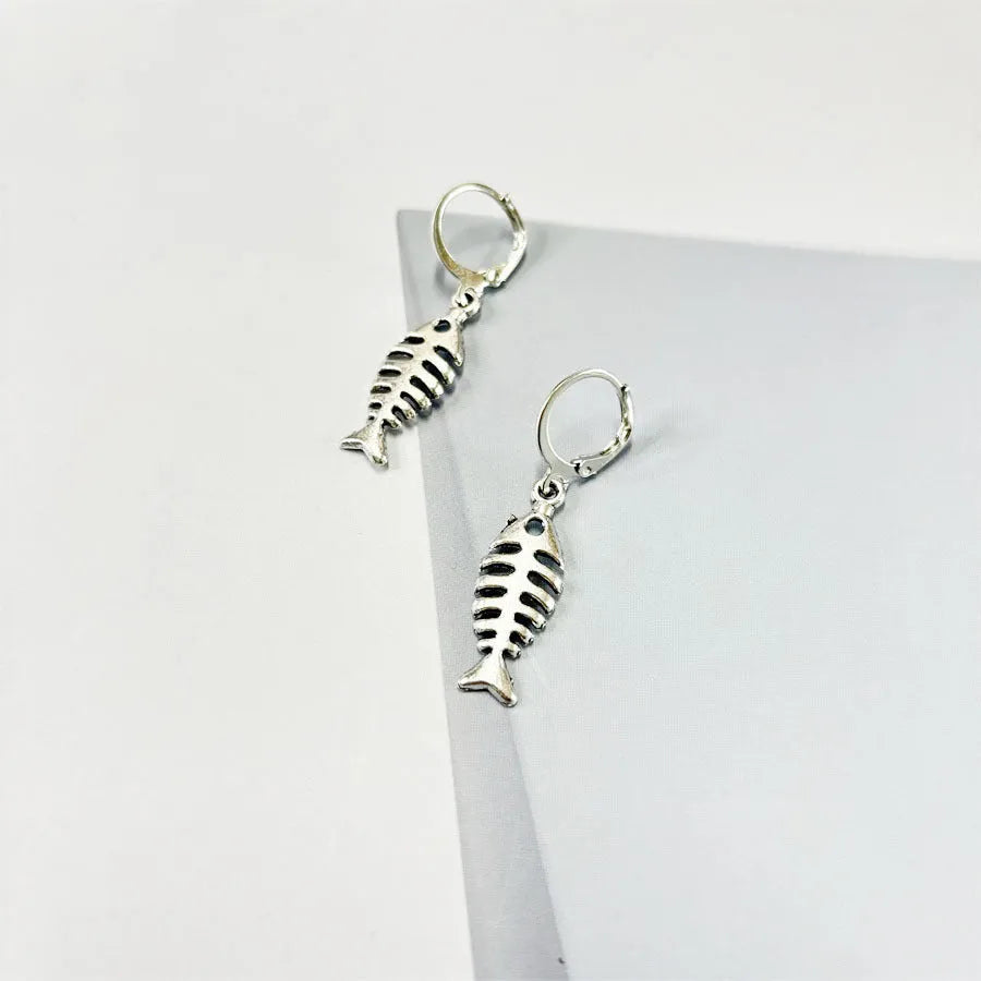 A pair of retro-style alloy earrings with a fishbone pendant hanging from an O-shaped chain.