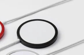 Silver metal magnetic wireless charger compatible with Apple Magsafe for iPhone.