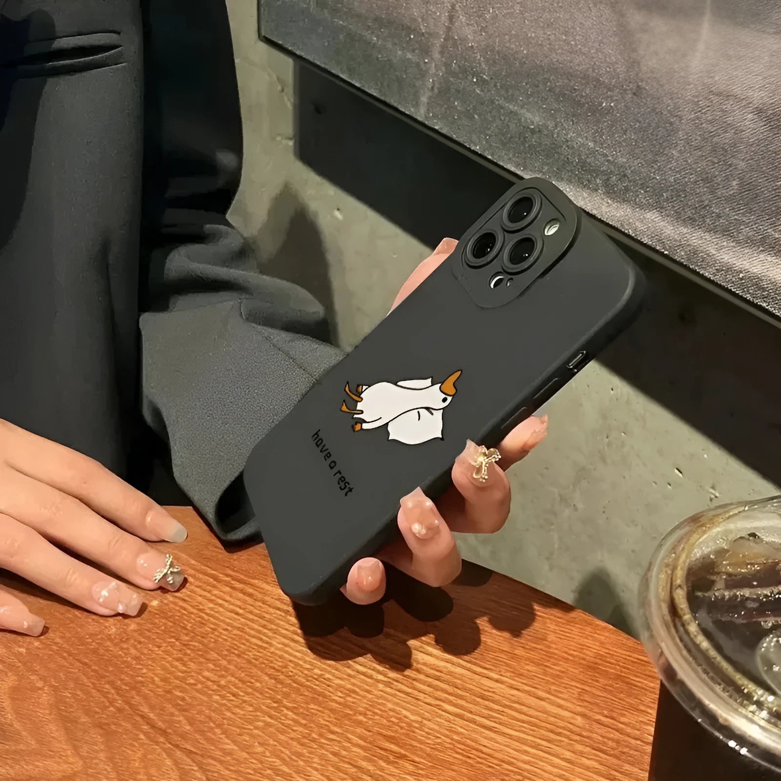 Cute carved cartoon duck design on a black silicone case for an iPhone.