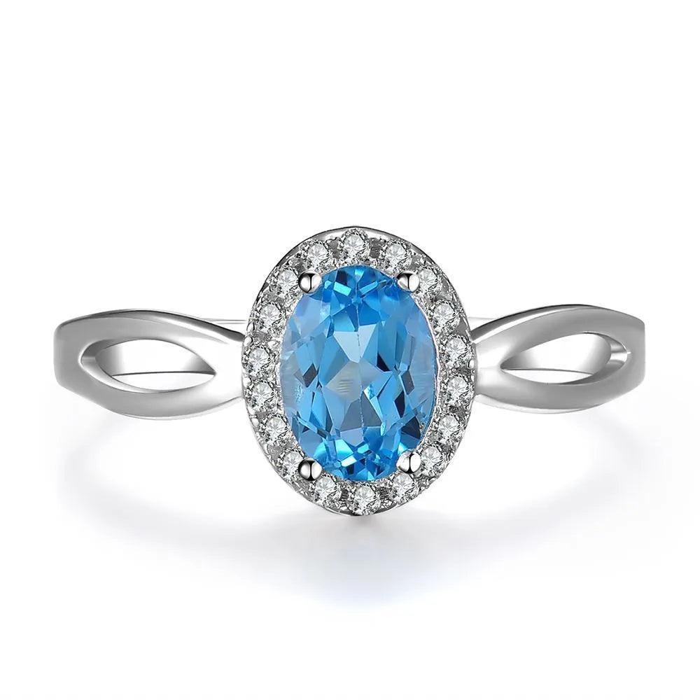 Four-piece sterling silver jewellery set with blue topaz: geometric earrings, ring, pendant, and necklace.