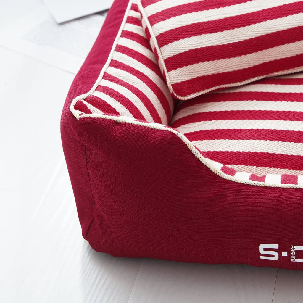 Navy stripes removable dog kennel mat and matching mini pillow set on a wooden floor