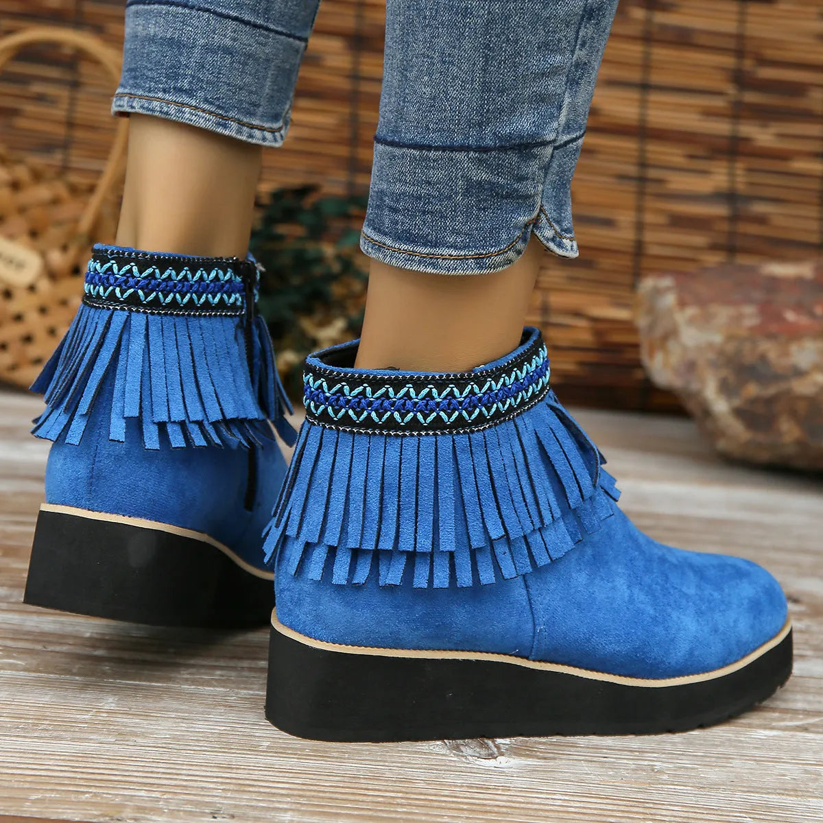Women's black suede wedge ankle boots with side zipper, tassel detail, and thick rubber sole.