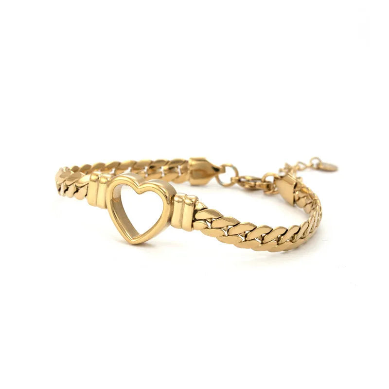 Fashion simple hollow heart titanium steel bracelet in BR-26 gold finish on a neutral background