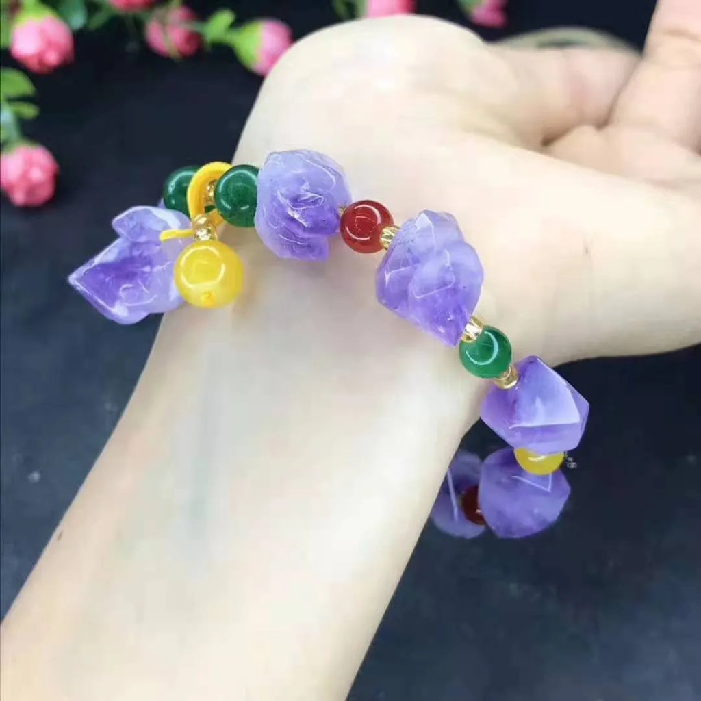 Women's amethyst bead bracelet with a Chinese fu character charm on a white background.