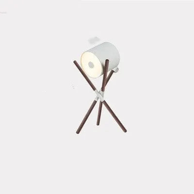 Modern three fork wooden floor lamp with an acrylic shade in a living room setting.