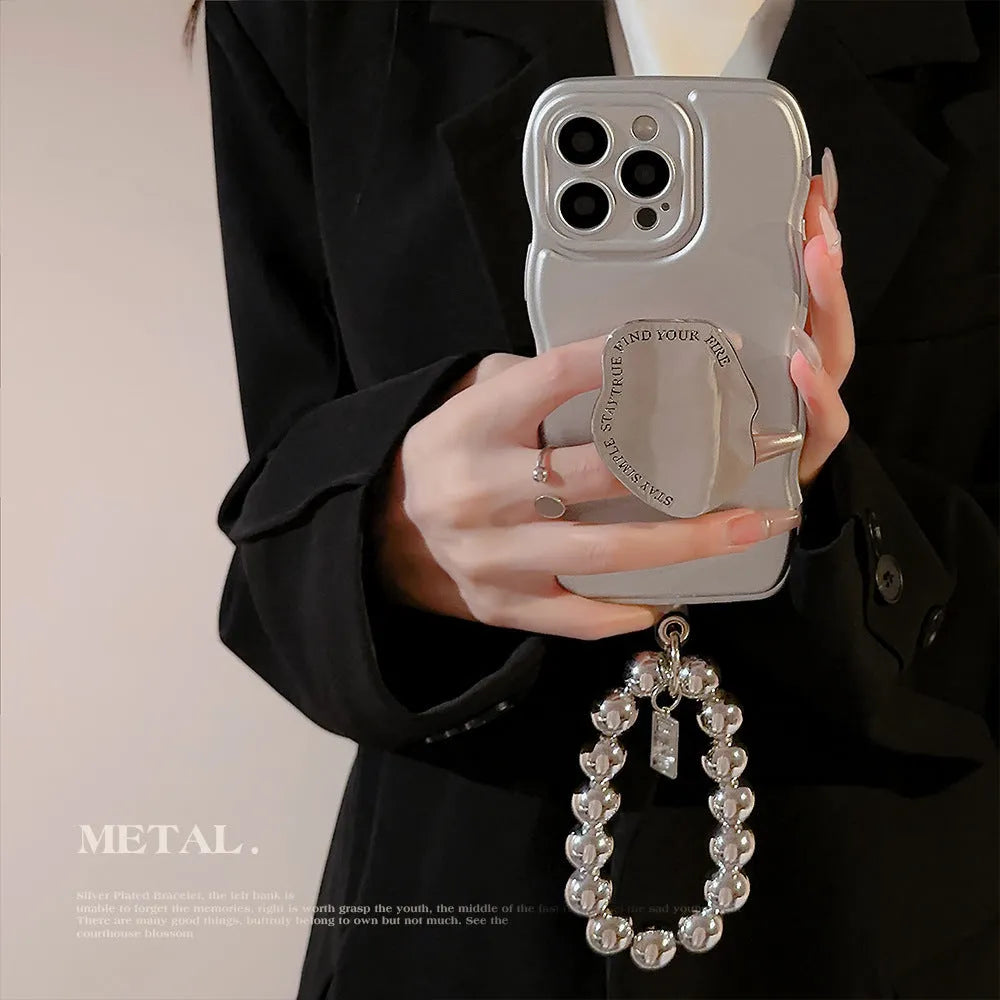 Silver metal bracket phone case for iPhone with electroplated finish and hand bead detail on gray background