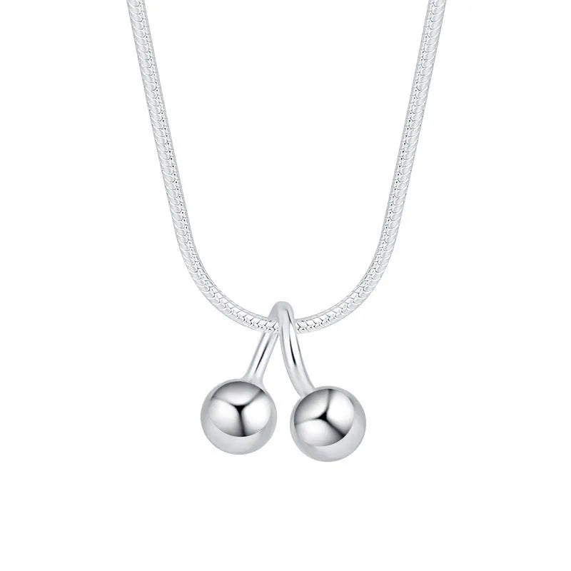 Silver cherry necklace for women with adjustable snake bone chain on a grey background.