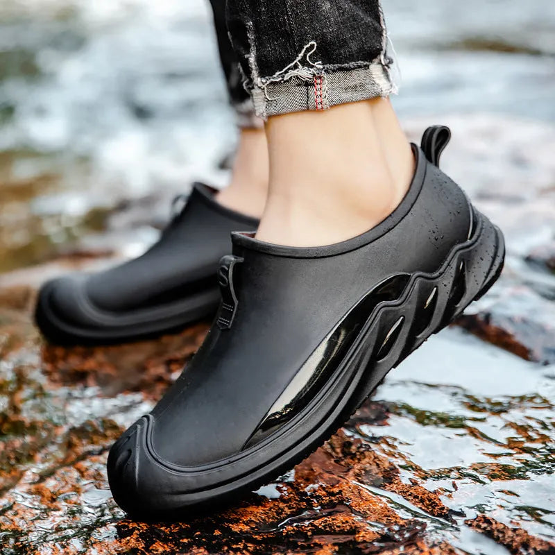 Men's black plastic rain boots showing short ankle height and solid colour design