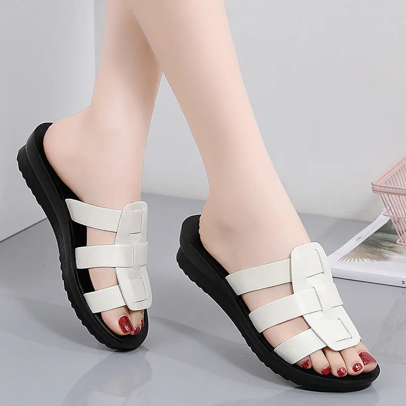 Beige women's flat bottom slippers with waxed leather upper and non-slip sole.