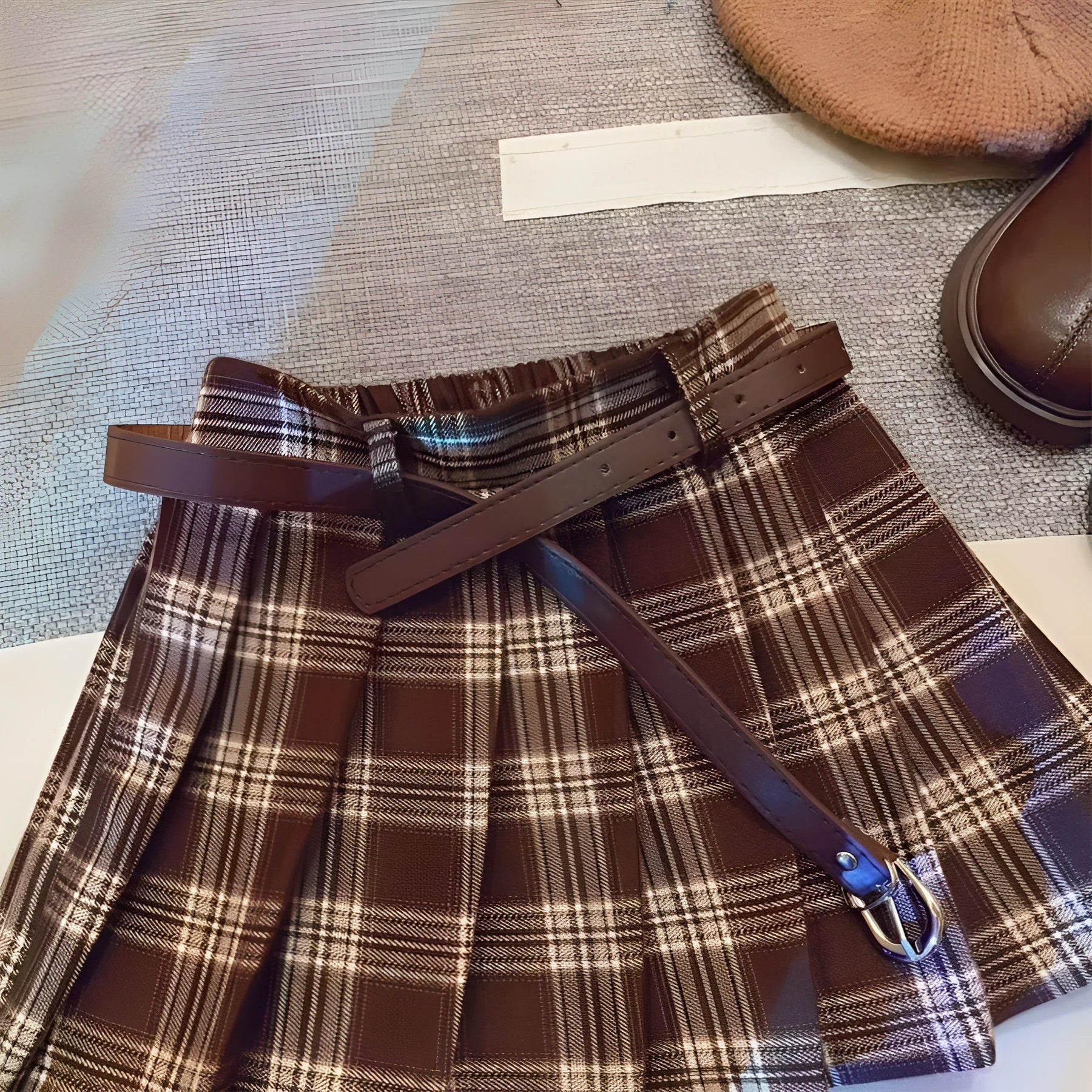 Girls cotton plaid pleated A-line skirt on a hanger, showing its length and pattern.