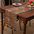 European retro style long table flag with handwoven tassels draped over a wooden sideboard