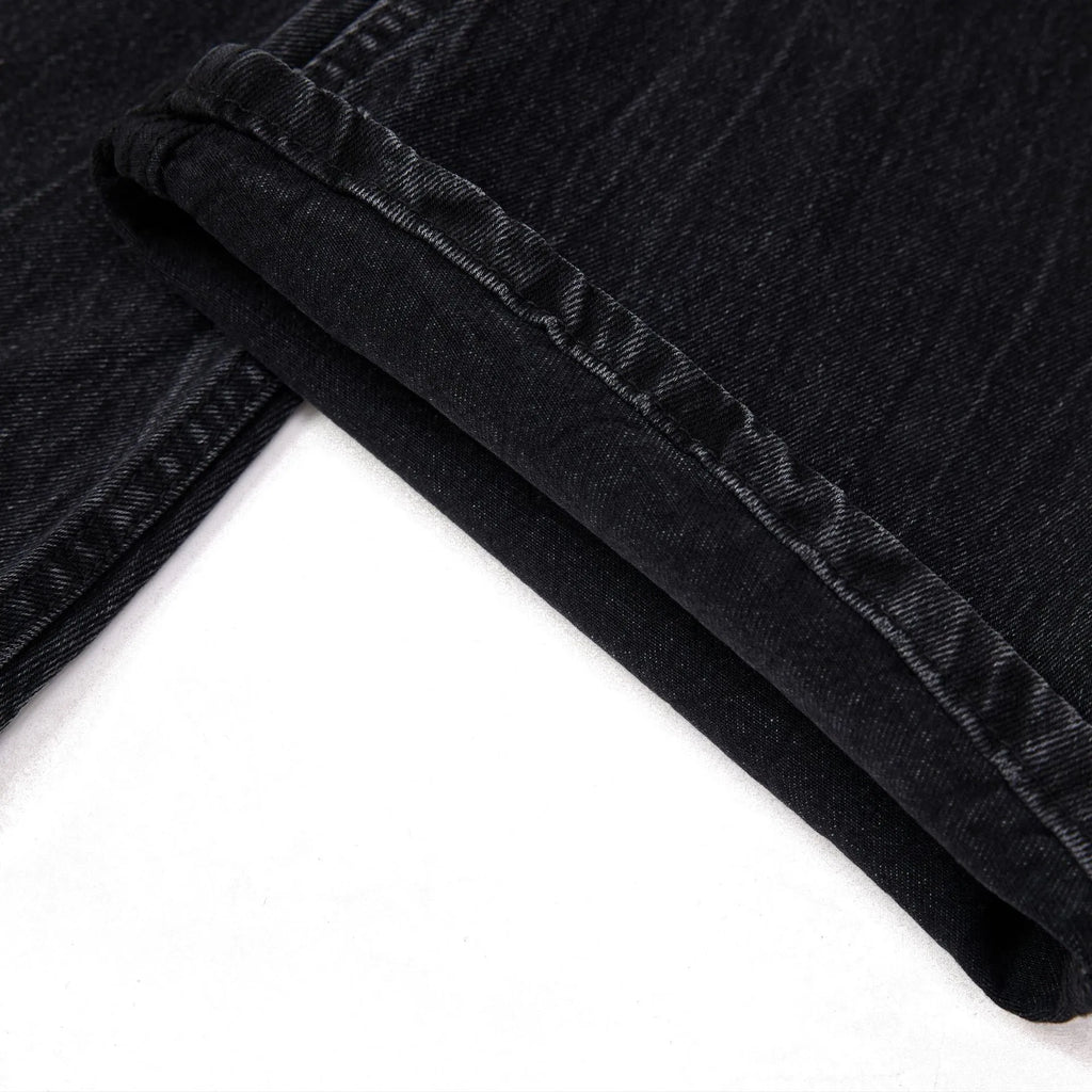 Black straight-leg jeans with lightning crack distressing pattern on knees and thighs