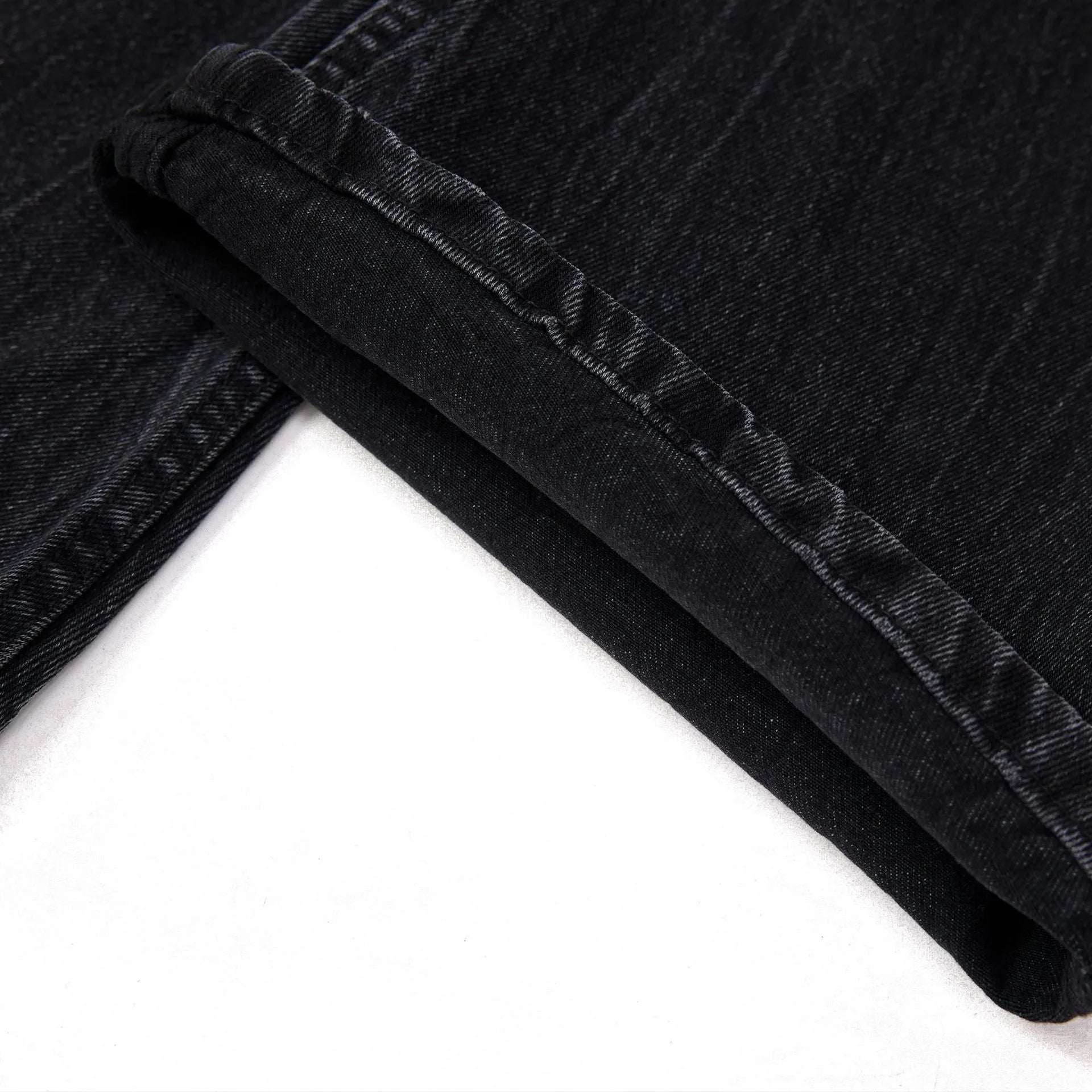 Black straight-leg jeans with lightning crack distressing pattern on knees and thighs
