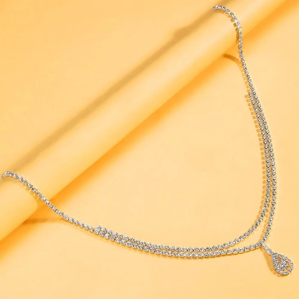 Gold rhinestone waist chain with water drop pendant and tassel detailing on adjustable 115 cm chain