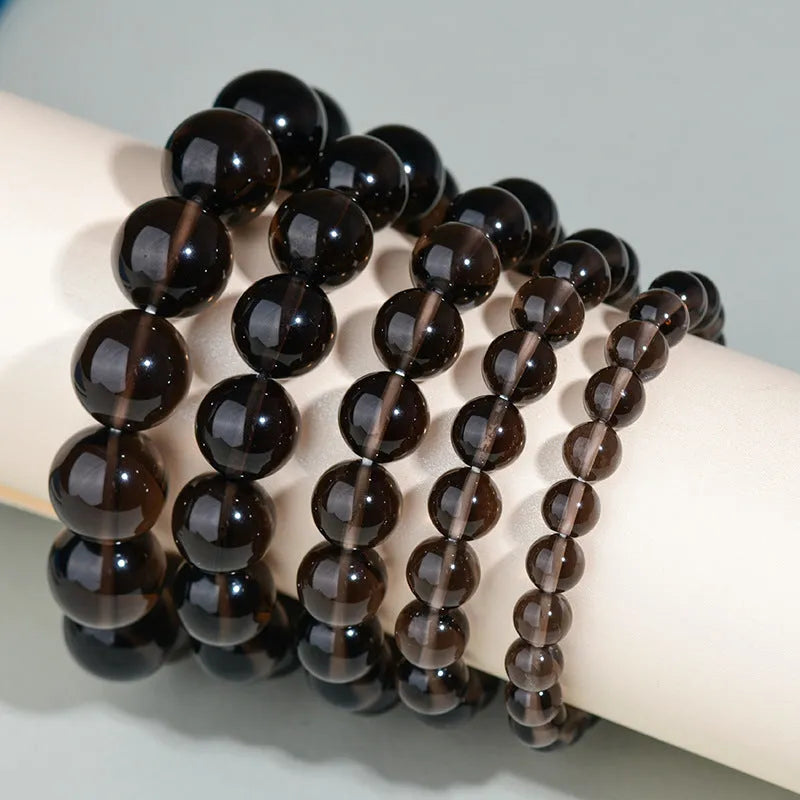 Hand-woven obsidian bracelet with round crystal beads in black stone variations including rainbow eye obsidian
