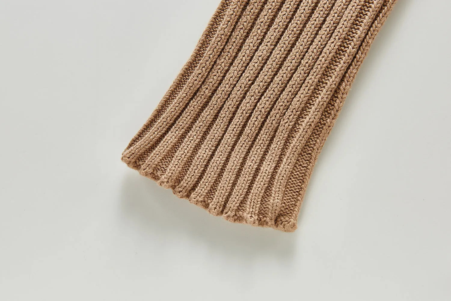 Baby long-sleeved knitted jumpsuit romper pullover in beige, size 80cm, lying flat on a white background