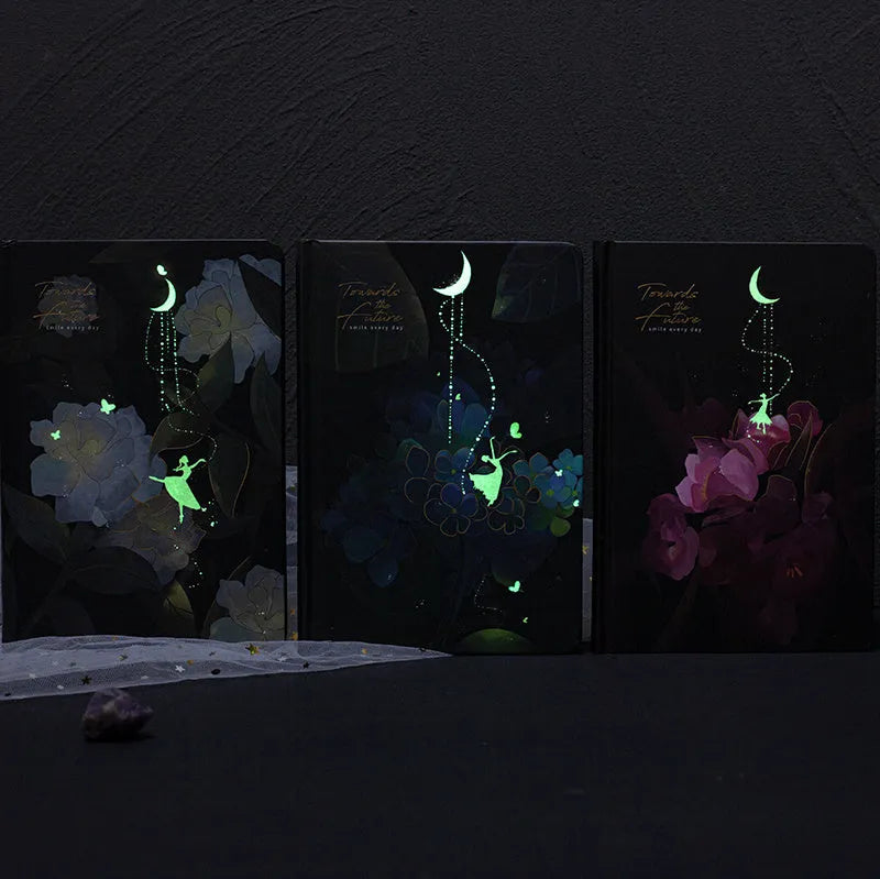 A5 notebook with luminous cover and silver foiling, open to show pages with colour illustrations.