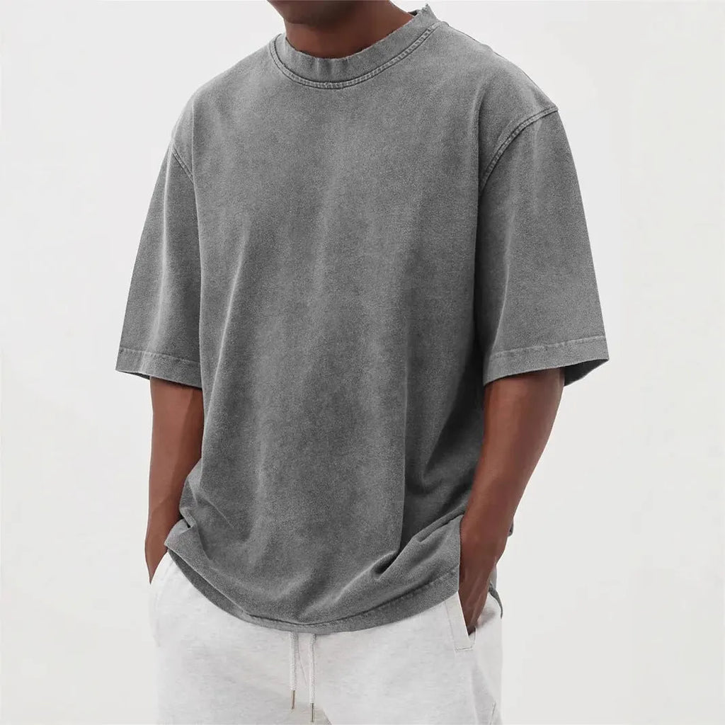 Man wearing a loose-fit, distressed army green pullover T-shirt with half sleeves.