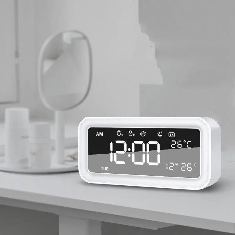Blue rectangular LED alarm clock with digital display on a table.