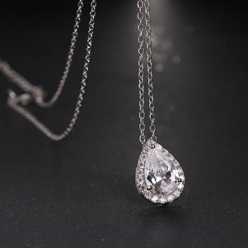 Women's water drop gemstone necklace and earrings set in copper with zircon on white background