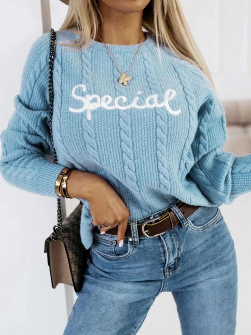 Blue crew neck pullover sweater with embroidered letter design on the chest.