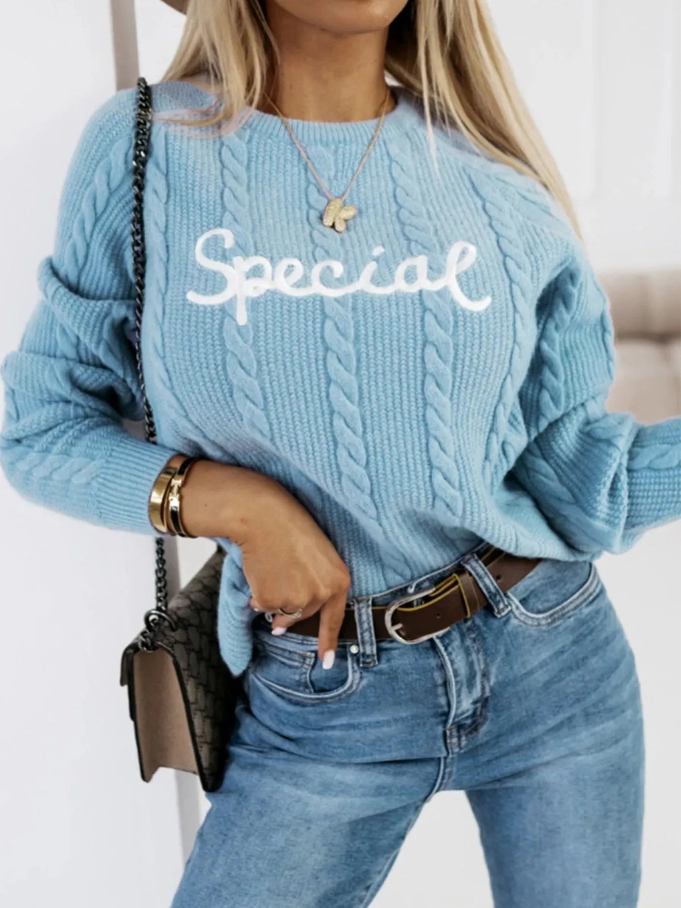 Blue crew neck pullover sweater with embroidered letter design on the chest.