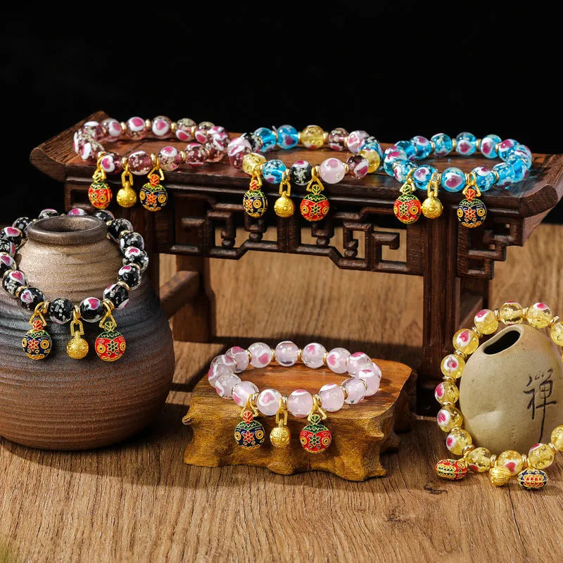 Glass bracelet with 10mm heart beads featuring ancient swallowing gold beast design in multiple colours