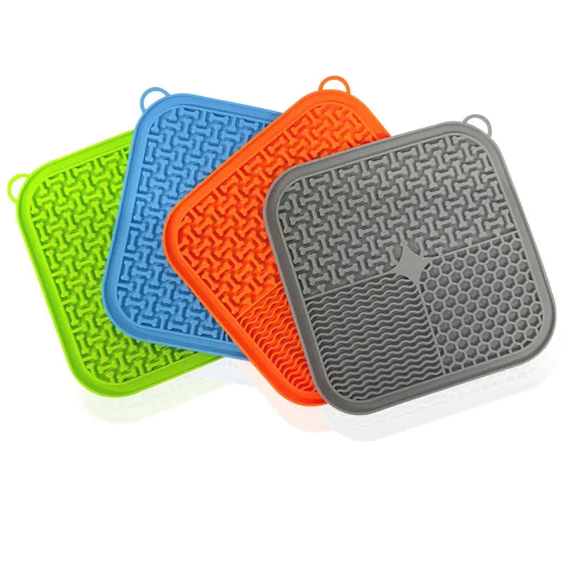 Square orange silicone dog licking mat with textured surface and suction cups on back.