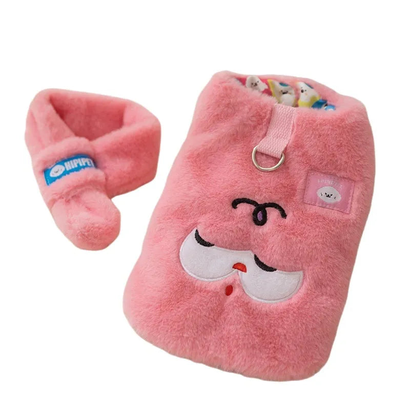 Small dog wearing a pink cartoon bear hoodie with matching detachable scarf, standing indoors