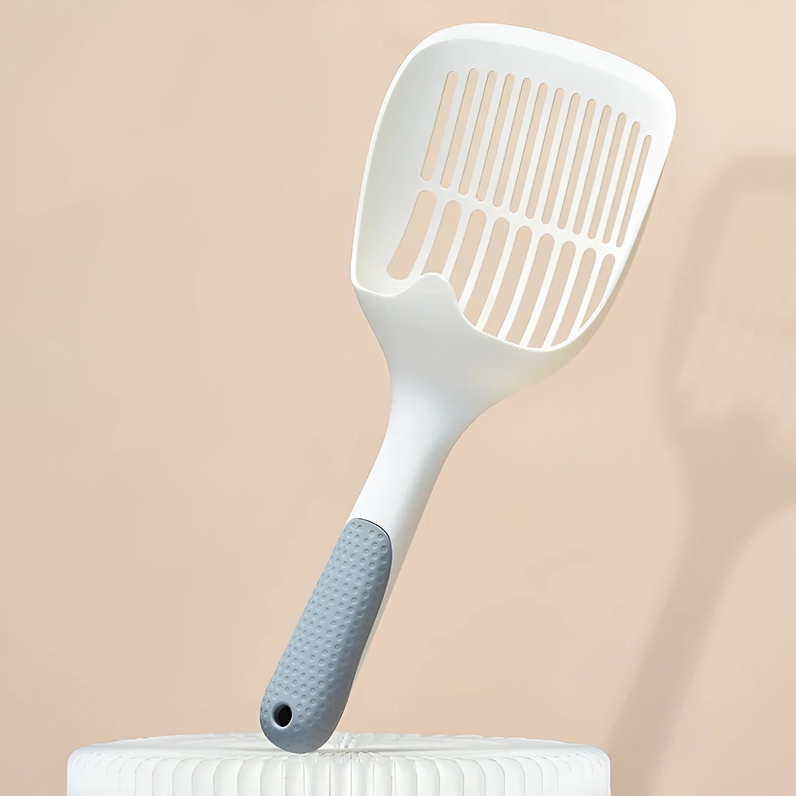 White plastic cat litter scoop with a storage base, shown with dimensions 29.5cm by 12.8cm.