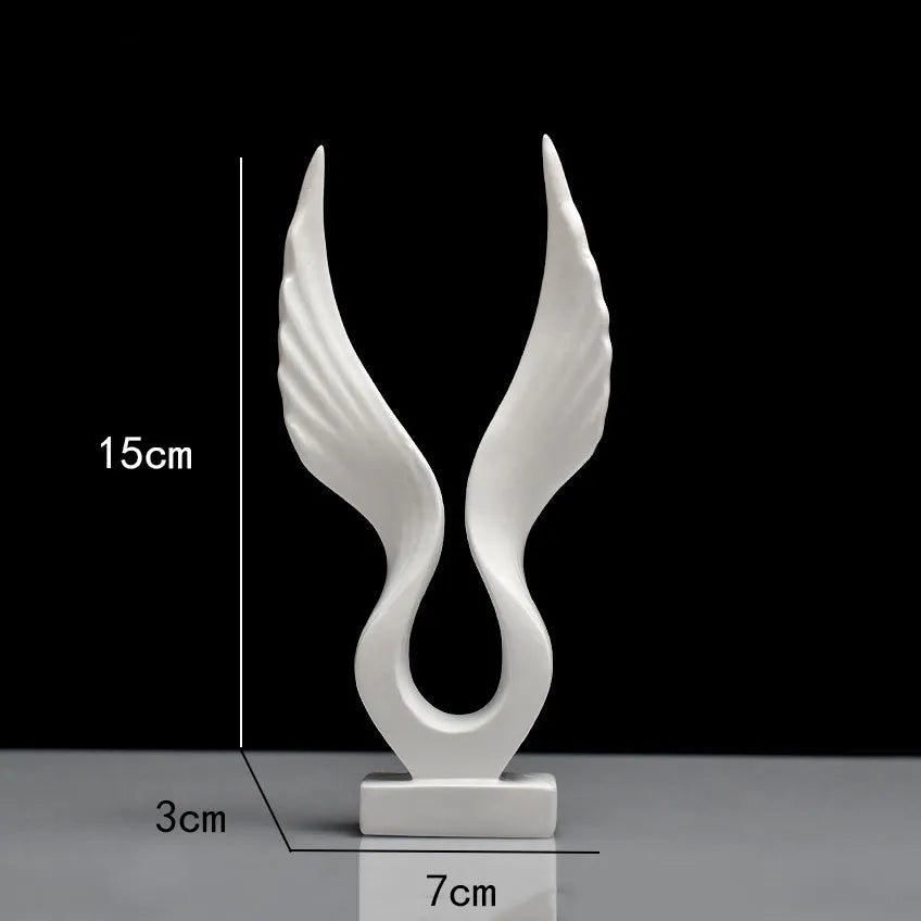 Mini synthetic resin decoration in silver and gold angel wing style on a shelf