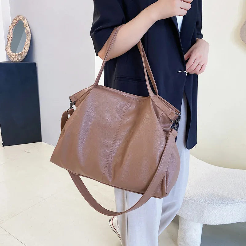 Soft surface PU leather messenger tote bag in a horizontal square shape with an adjustable shoulder strap.