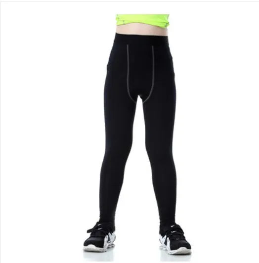 Children's sportswear set showing black and green t-shirts, shorts, and trousers for football and active play.