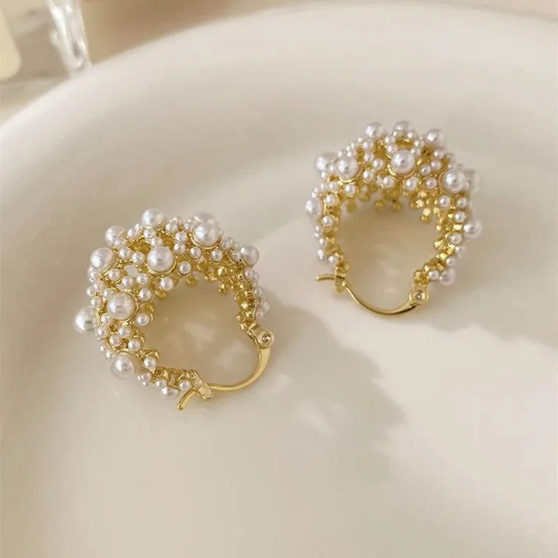 Gold-coloured copper flower basket earrings with small rice-shaped beads and pearl inlay detailing.