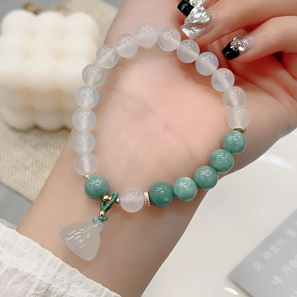 Close-up of a women's retro style agate bracelet with a lotus seedpod design.